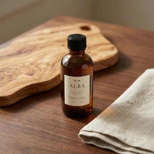 Alba olive wood care oil beside an olive wood board
